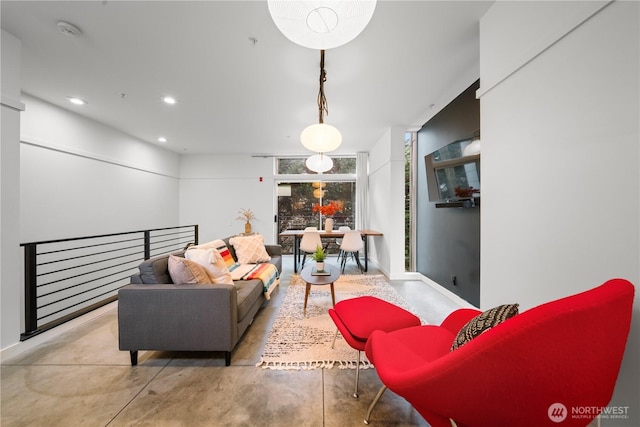 living room with recessed lighting, baseboards, and concrete flooring