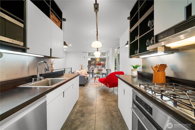 kitchen featuring a sink, stainless steel appliances, tasteful backsplash, and white cabinetry