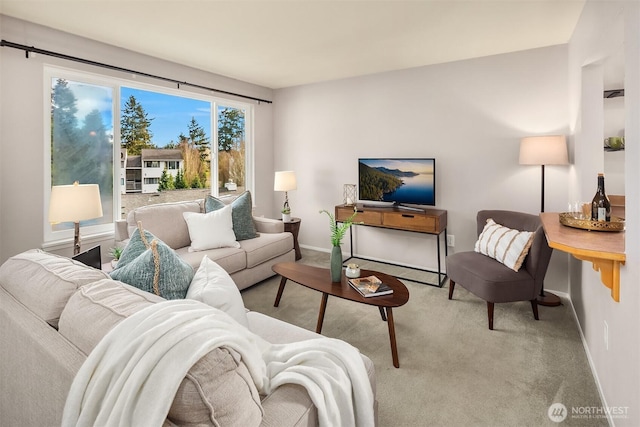 carpeted living area with baseboards