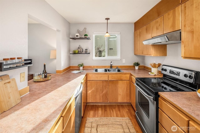 kitchen with appliances with stainless steel finishes, decorative light fixtures, under cabinet range hood, open shelves, and a sink