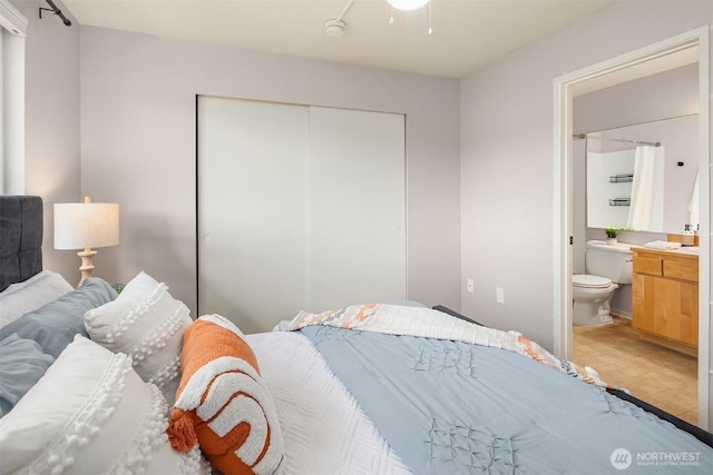 bedroom featuring a closet, light tile patterned flooring, and connected bathroom