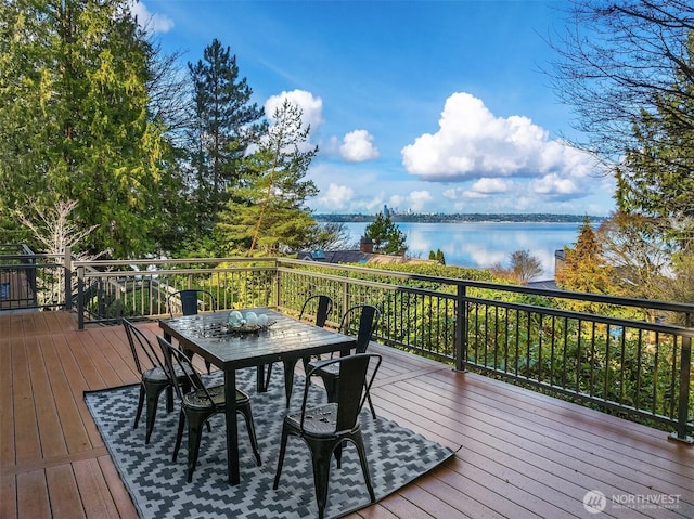 wooden deck featuring outdoor dining space and a water view