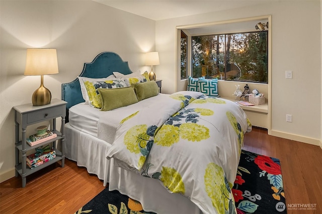 bedroom with wood finished floors and baseboards