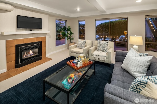 living area featuring beam ceiling, a tiled fireplace, recessed lighting, carpet floors, and baseboards