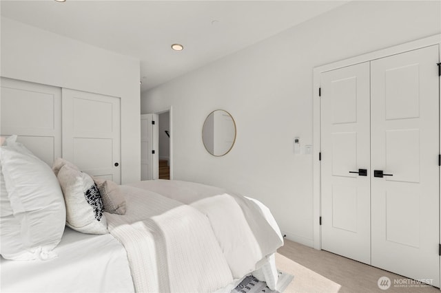 bedroom with recessed lighting, a closet, light colored carpet, and baseboards