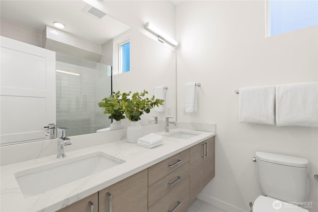 bathroom with visible vents, a sink, toilet, and a tile shower