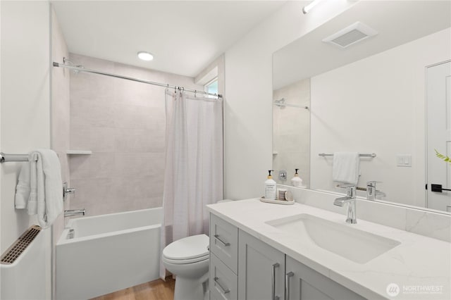 bathroom featuring visible vents, toilet, wood finished floors, shower / bath combination with curtain, and vanity