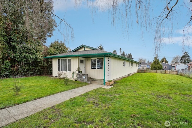 bungalow-style home with a front lawn and fence