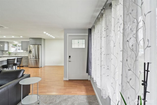 living room with light wood-style flooring, recessed lighting, and baseboards