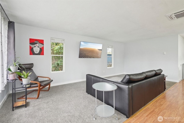 living room featuring carpet flooring, baseboards, and visible vents