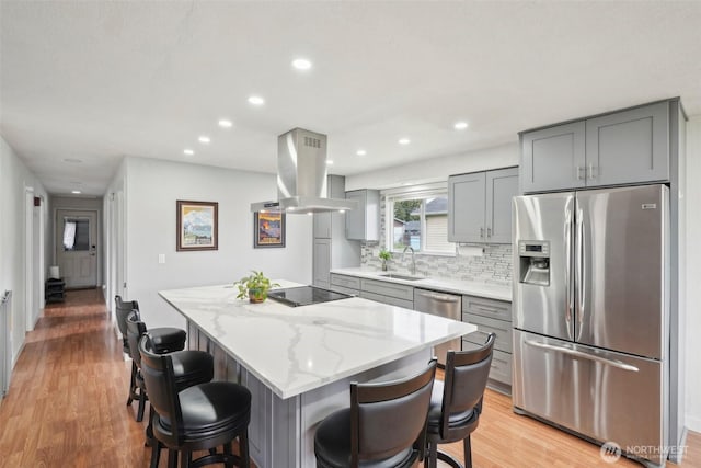 kitchen featuring a sink, gray cabinetry, island exhaust hood, and stainless steel appliances