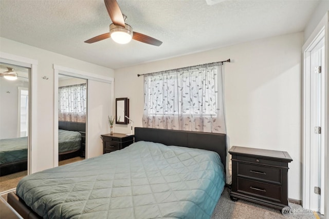 bedroom featuring carpet flooring, multiple windows, a ceiling fan, and a textured ceiling