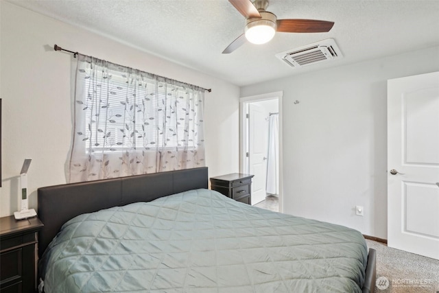 carpeted bedroom with ceiling fan, baseboards, visible vents, and a textured ceiling