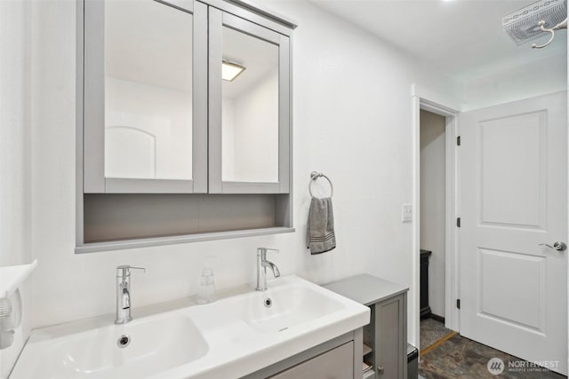 bathroom with a sink, stone finish floor, visible vents, and double vanity