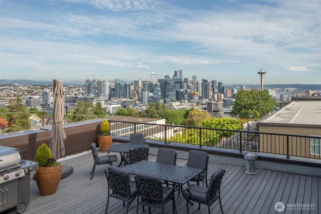 deck with outdoor dining area and a city view