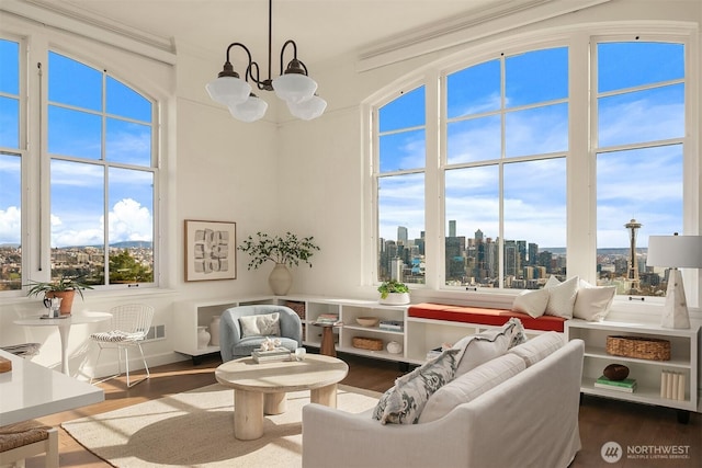 living area with a city view, an inviting chandelier, and wood finished floors