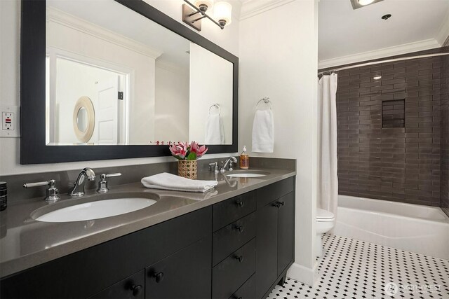 bathroom featuring crown molding, toilet, and a sink