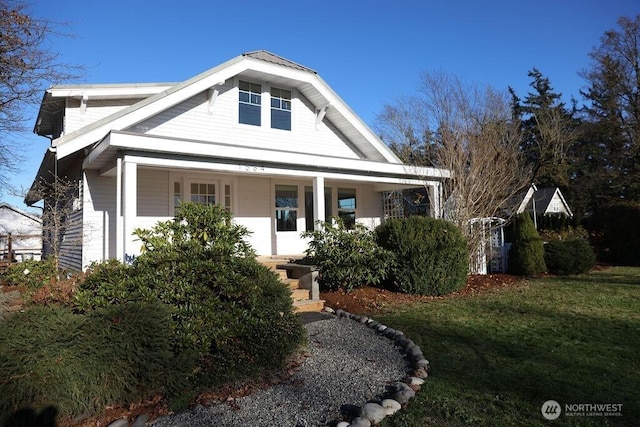 view of front facade featuring covered porch and a front lawn