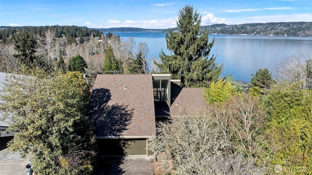 birds eye view of property featuring a forest view and a water view