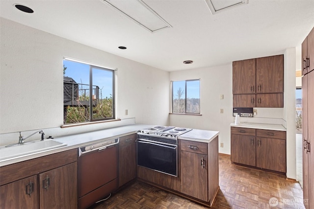 kitchen featuring a wealth of natural light, electric range, a sink, dishwasher, and a peninsula