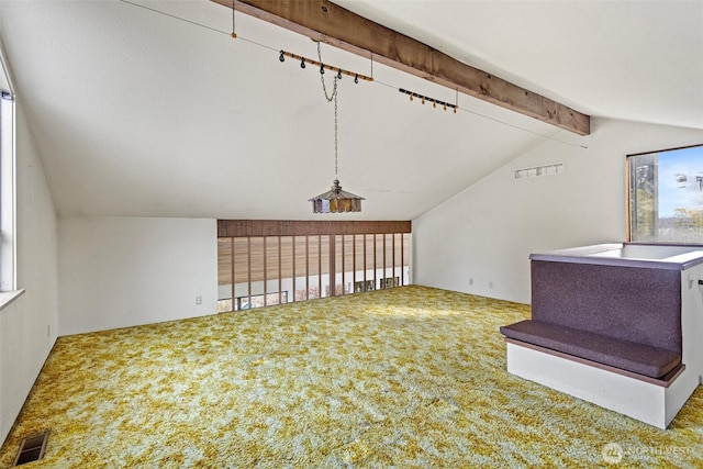 additional living space with carpet, a healthy amount of sunlight, visible vents, and lofted ceiling with beams