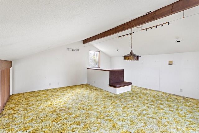 unfurnished room with carpet flooring, lofted ceiling with beams, and a textured ceiling