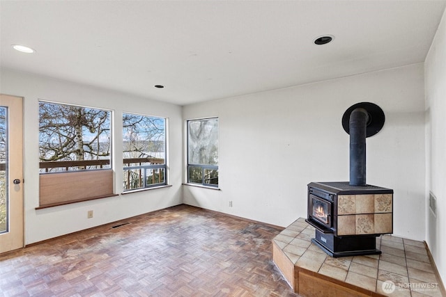 interior space with recessed lighting, a wood stove, and visible vents