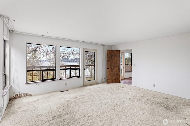 empty room with carpet floors and visible vents