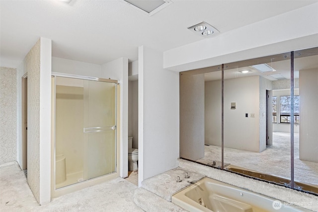 bathroom with a garden tub, a shower stall, and toilet