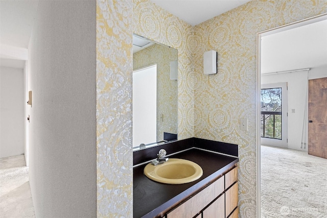 bathroom featuring wallpapered walls and vanity