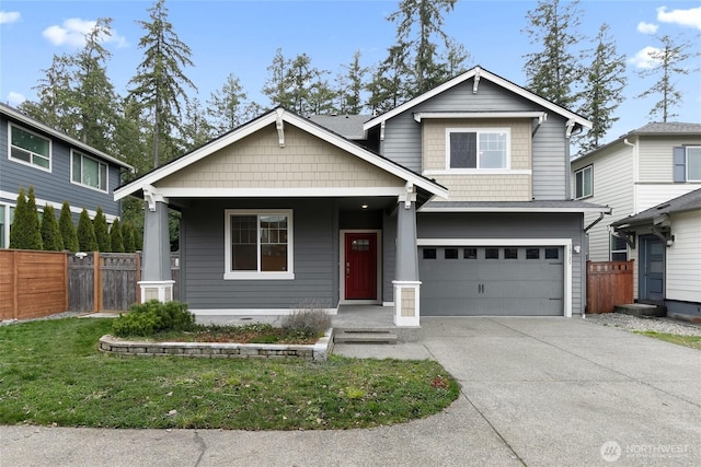 craftsman house featuring a front lawn, concrete driveway, an attached garage, and fence