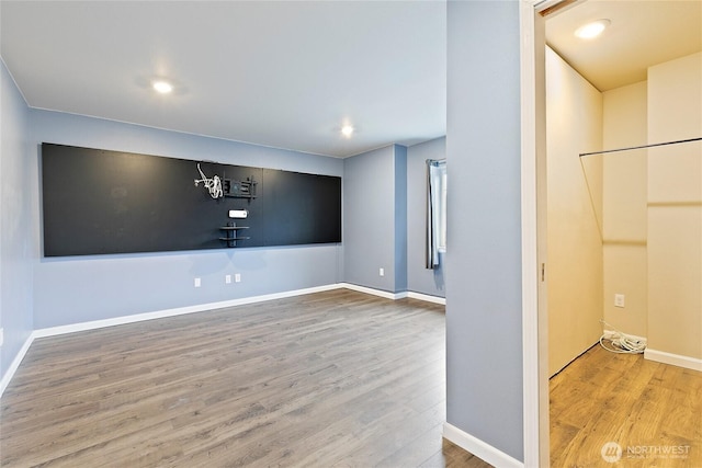 empty room featuring recessed lighting, wood finished floors, and baseboards