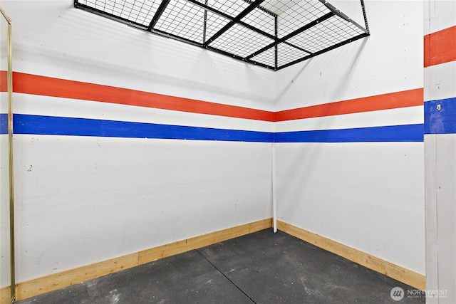 empty room featuring baseboards and concrete floors