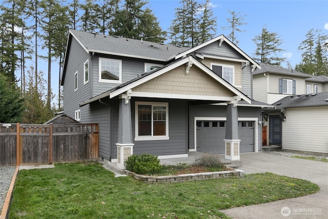 view of front facade featuring concrete driveway, fence, a garage, and a front lawn