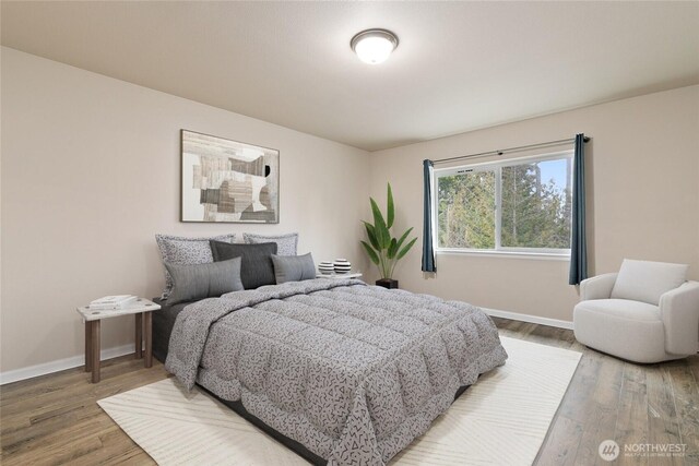 bedroom featuring baseboards and wood finished floors