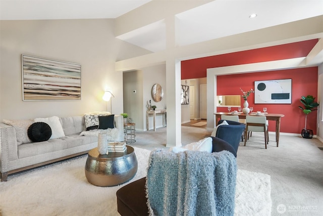 living area featuring carpet floors, high vaulted ceiling, and baseboards