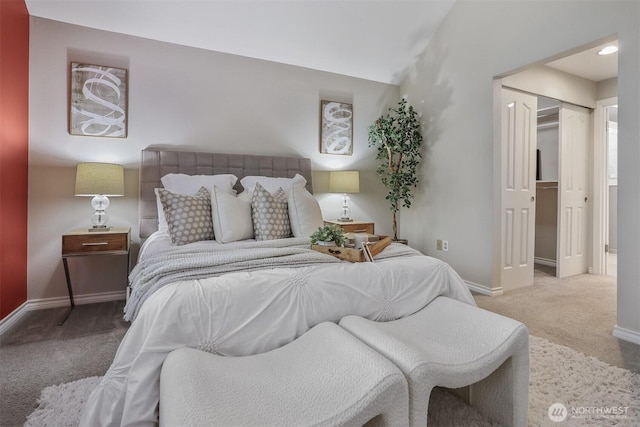 bedroom with a closet, carpet flooring, vaulted ceiling, and baseboards