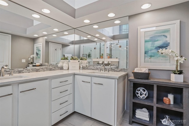 bathroom with double vanity, a shower stall, a sink, and recessed lighting