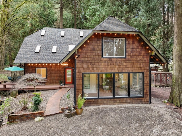 back of house featuring a wooden deck and a shingled roof