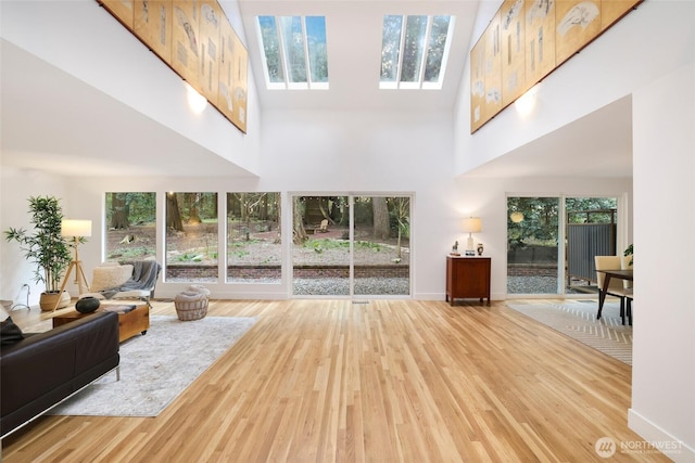 living room featuring a high ceiling, wood finished floors, and baseboards