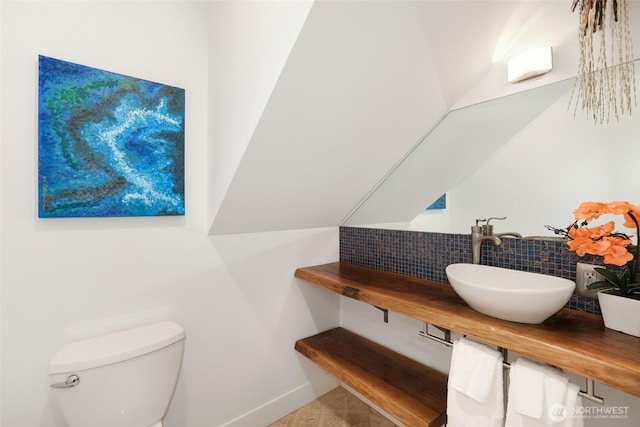 bathroom with baseboards, toilet, decorative backsplash, tile patterned floors, and vanity