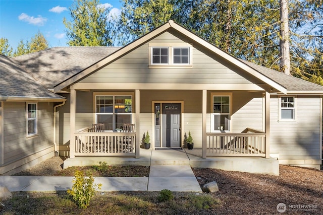 bungalow-style home with covered porch, crawl space, and roof with shingles