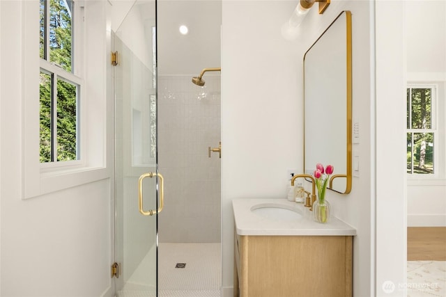 full bath featuring vanity, a shower stall, and plenty of natural light