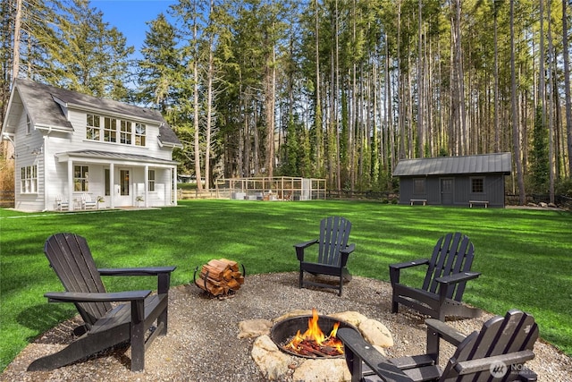 view of yard featuring a fire pit and an outdoor structure