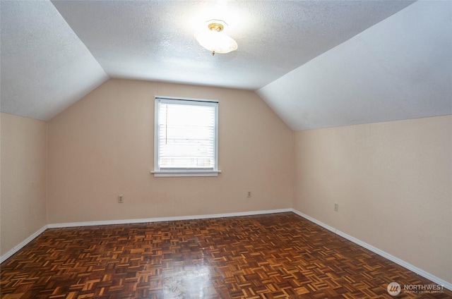 bonus room with baseboards, a textured ceiling, and vaulted ceiling