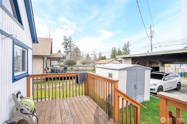 wooden terrace featuring a yard, a storage shed, an outdoor structure, and fence