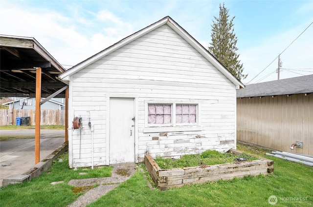 view of outbuilding featuring an outbuilding, a vegetable garden, and fence