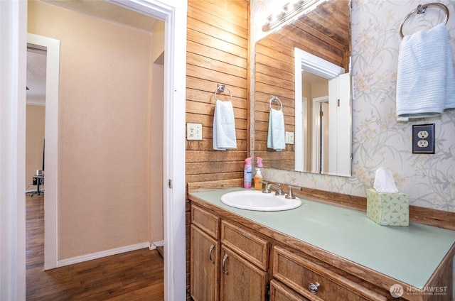 bathroom with vanity, baseboards, and wood finished floors