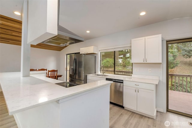 kitchen featuring appliances with stainless steel finishes, a peninsula, island range hood, white cabinets, and a sink