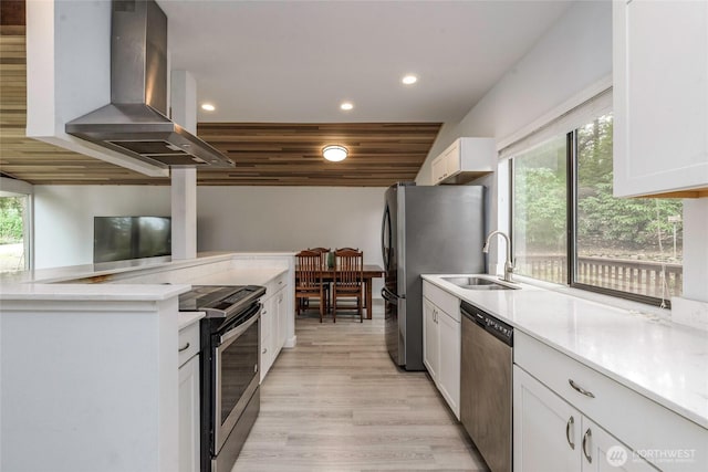 kitchen featuring recessed lighting, appliances with stainless steel finishes, island exhaust hood, white cabinets, and a sink